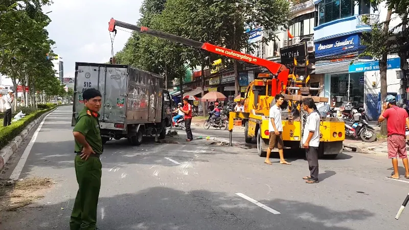 Chiếc xe tải chở bia do tránh một người phụ nữ điều khiển xe máy thì bị lật trên đường Điện Biên Phủ